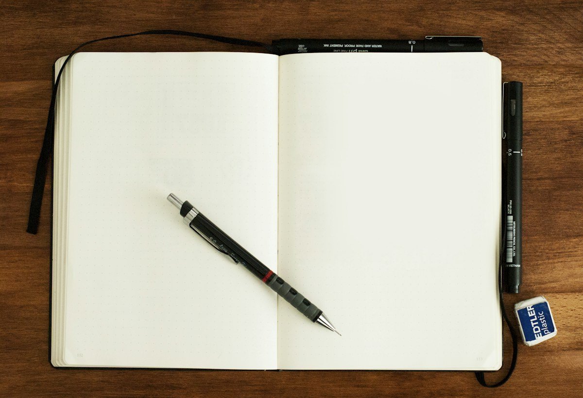 Aufgeschlagenes Heft mit Stift